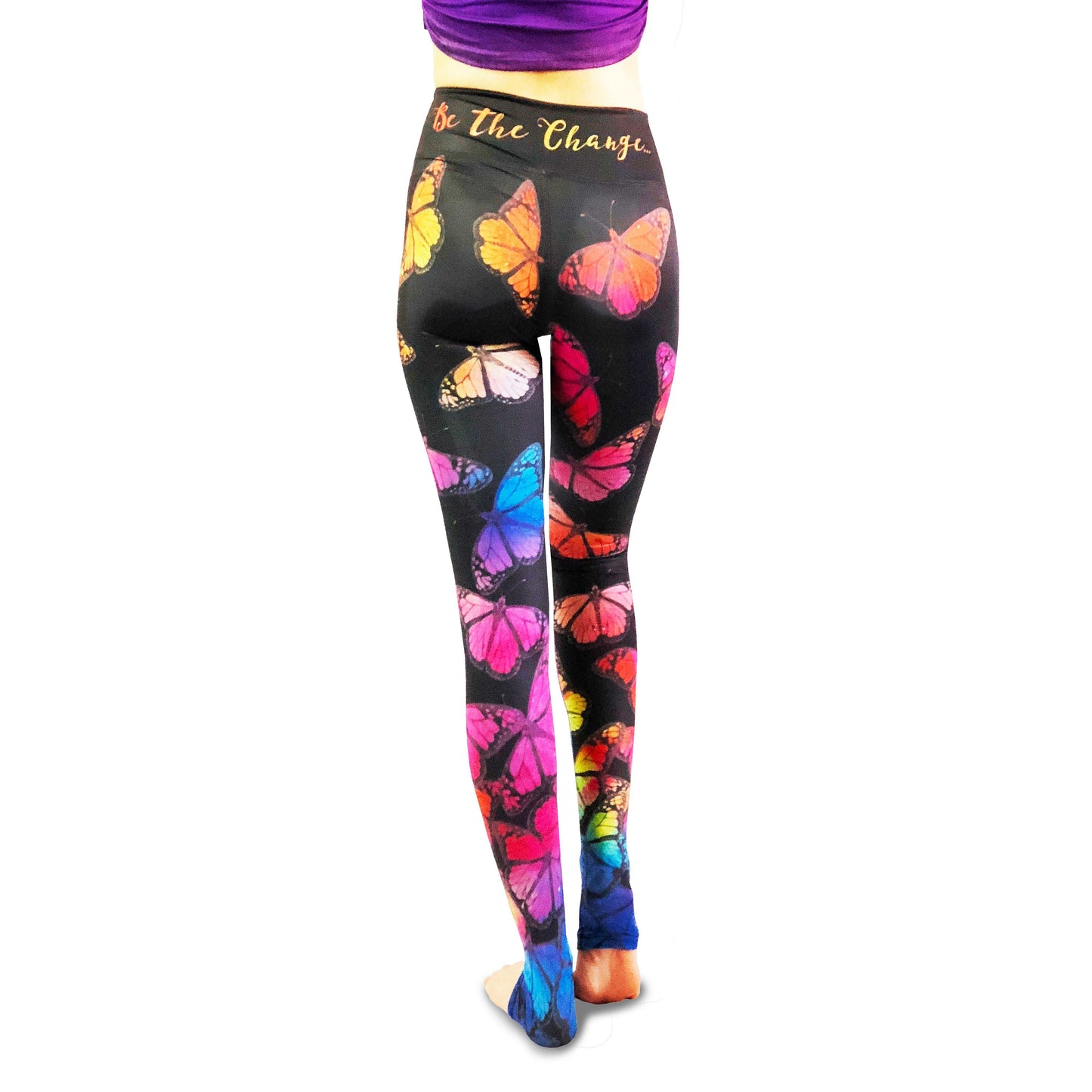 Woman wearing black leggings with rainbow butterfly print leggings.