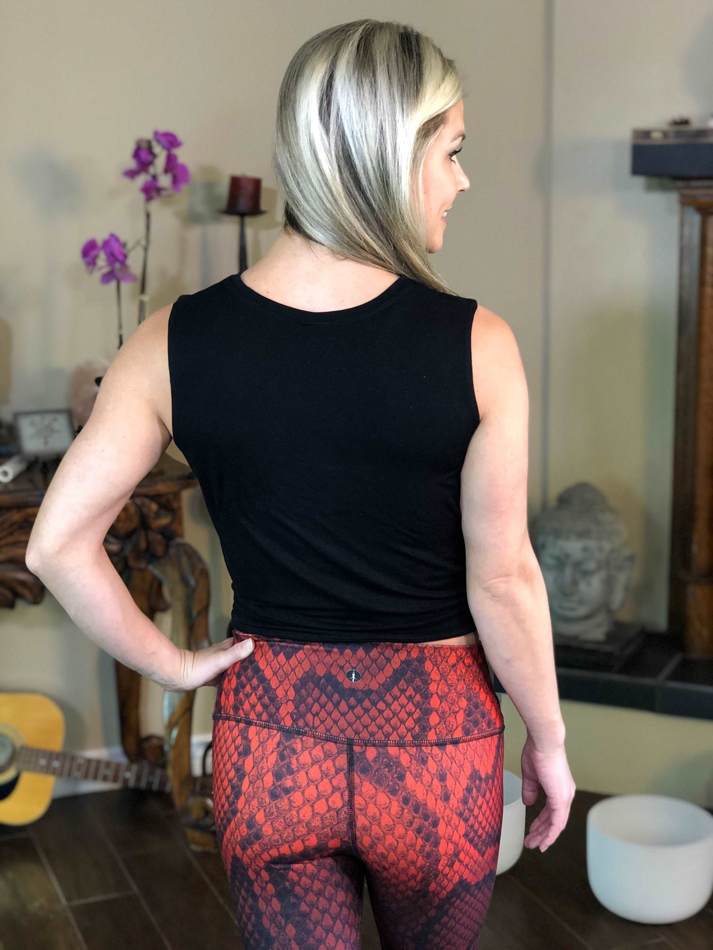 Woman wearing black tie-front tank top with geometric flower on it.