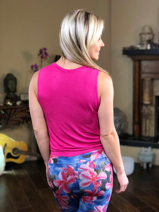 Woman wearing pink tie-front tank top with dandelion on the front.