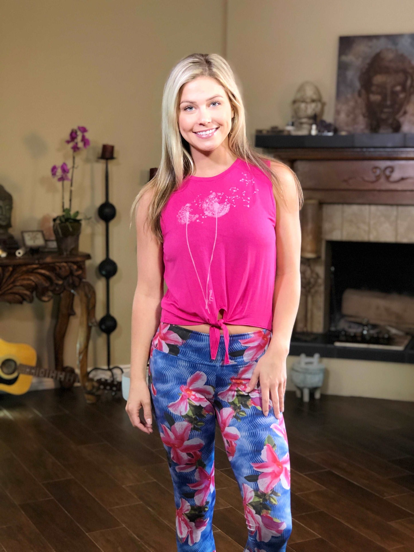 Woman wearing pink tie-front tank top with dandelion on the front.
