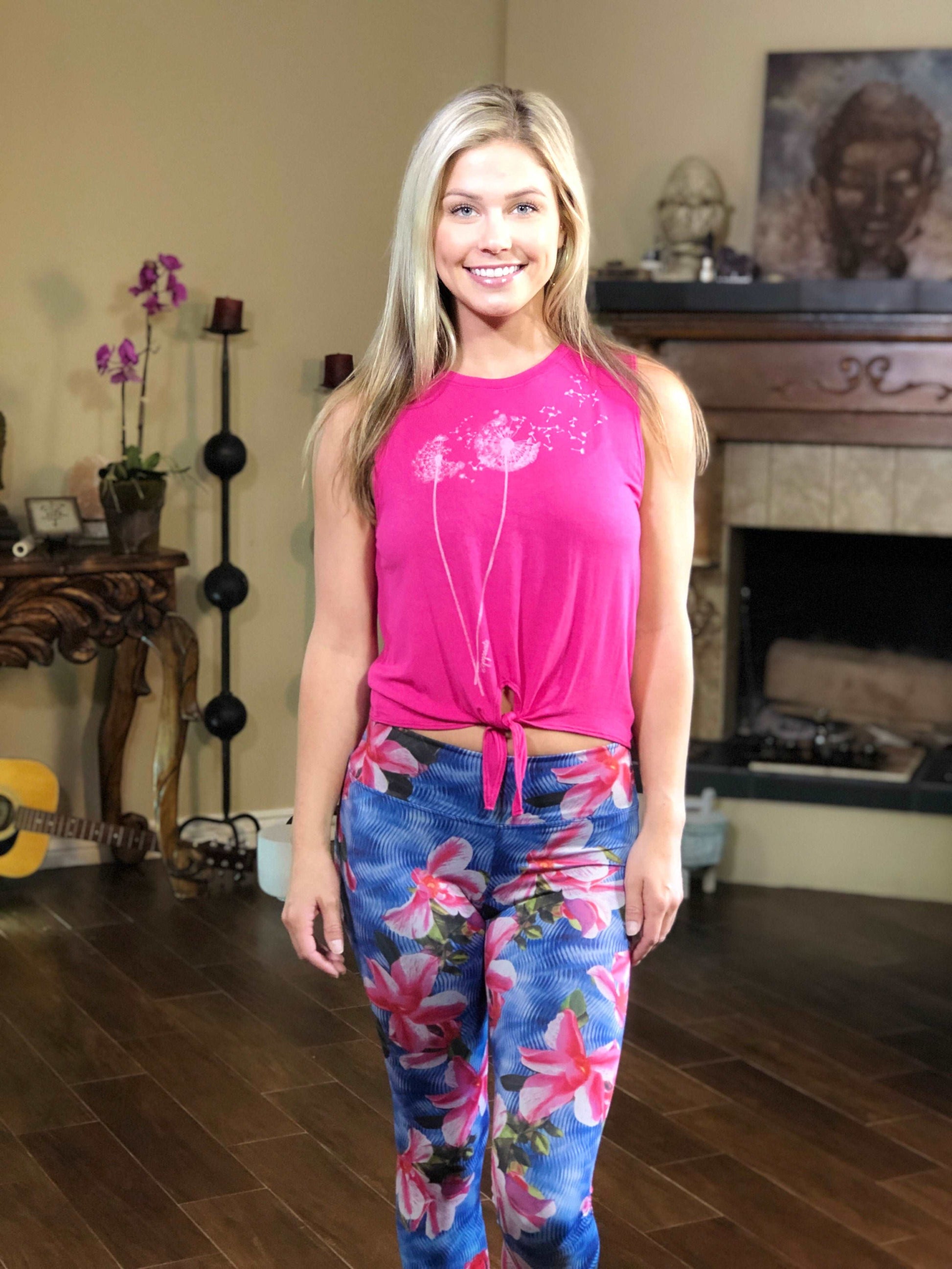 Woman wearing pink tie-front tank top with dandelion on the front.