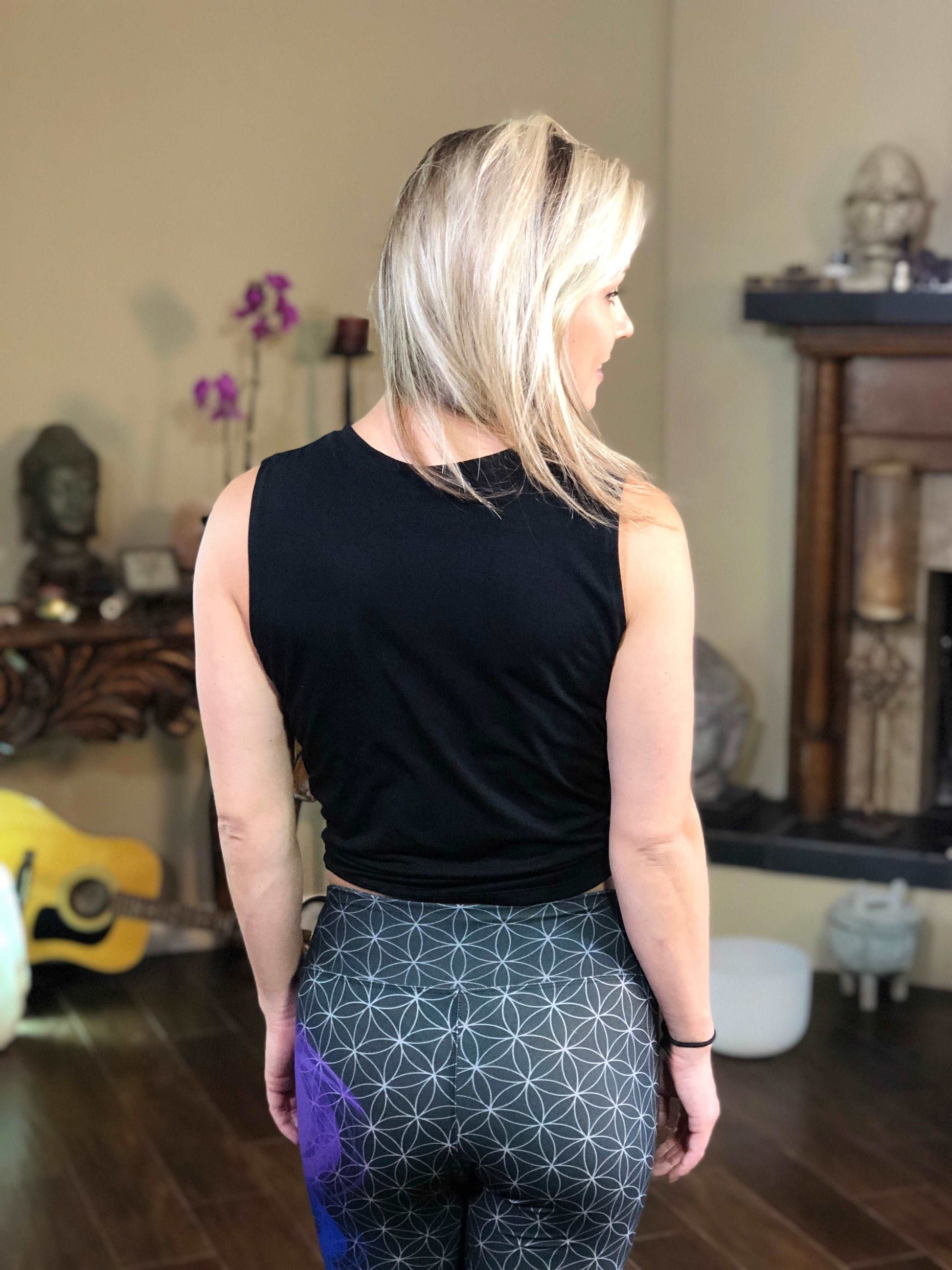 Back of woman wearing black tie-front tank top with white kiss lips.