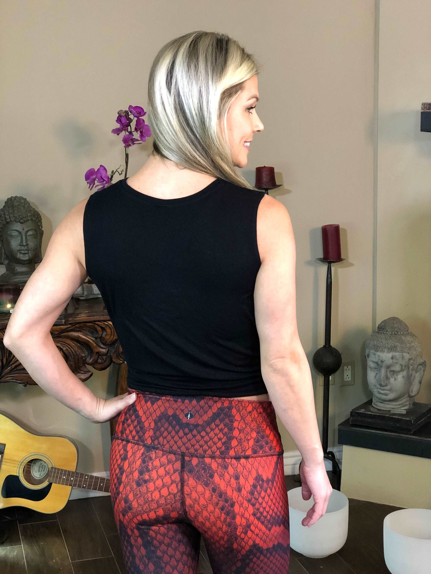 Woman wearing black tie-front tank top with geometric flower on it.