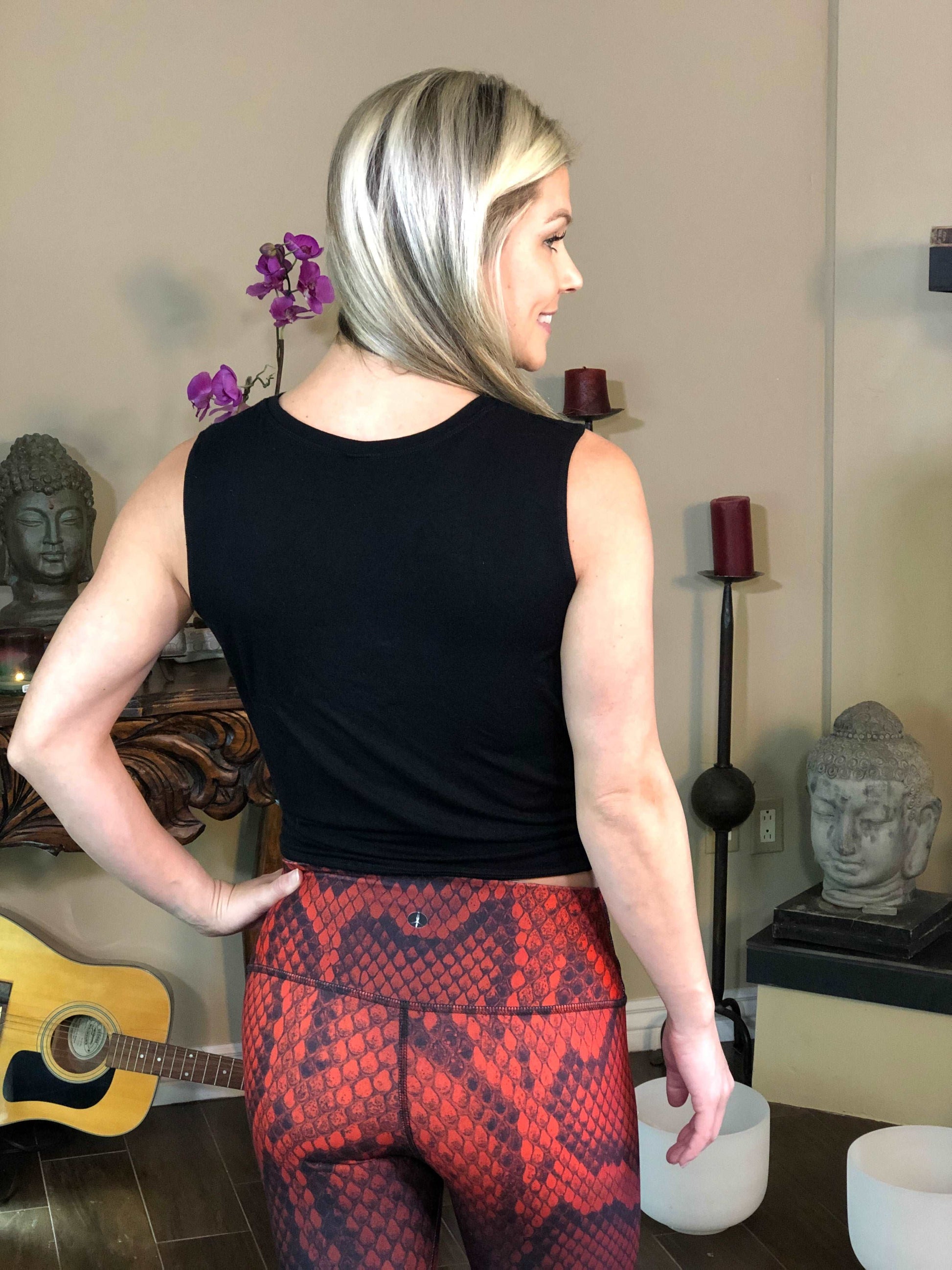Woman wearing black tie-front tank top with geometric flower on it.