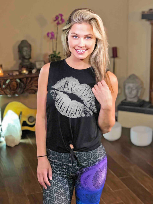 Woman wearing black tie-front tank top with white kiss lips.